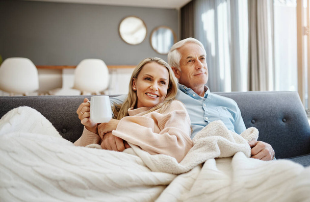 Выход на пенсию означает больше времени для качественного времени. счастливая зрелая пара отдыхает на диване дома - Фото, изображение