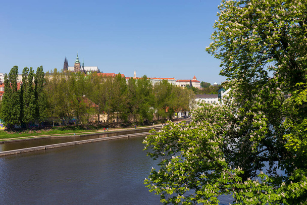 Çek Cumhuriyeti 'nin güneşli bir gününde Vltava Nehri üzerinde Gotik Şatosu olan Bahar Renkli Prag Küçük Kasabası - Fotoğraf, Görsel
