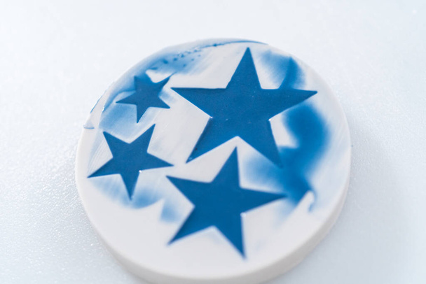 Enchendo o molde de silicone em forma de estrela com chocolate de cor derretida. - Foto, Imagem