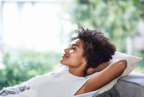 Relax, smile and black woman on sofa sleeping, afternoon nap and rest in calm apartment on weekend. Sleep, daydream ideas and girl on couch relaxing, self care and stress free chill time in lounge - 写真・画像