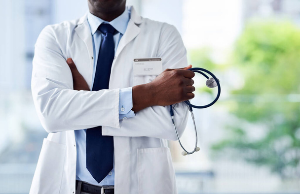 Αν είσαι άρρωστος υπάρχει μόνο ένα άτομο που πρέπει να καλέσεις. ένας αγνώριστος γιατρός που στέκεται με τα χέρια του διπλωμένα μέσα σε ένα νοσοκομείο κατά τη διάρκεια της ημέρας - Φωτογραφία, εικόνα