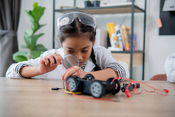 Asian students learn at home in coding robot cars and electronic board cables in STEM, STEAM, mathematics engineering science technology computer code in robotics for kids concept. - Fotoğraf, Görsel