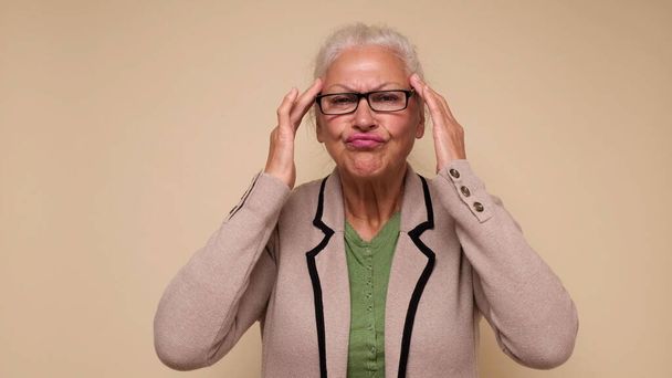 Anciana europea sufre de dolor de cabeza y sostiene sus dedos en las sienes - Foto, imagen