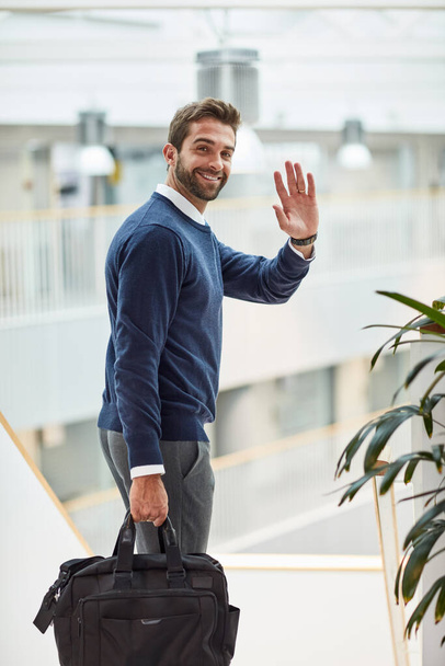 See you once Ive claimed by next big success. Portrait of a young businessman waving while carrying a bag - Foto, Bild