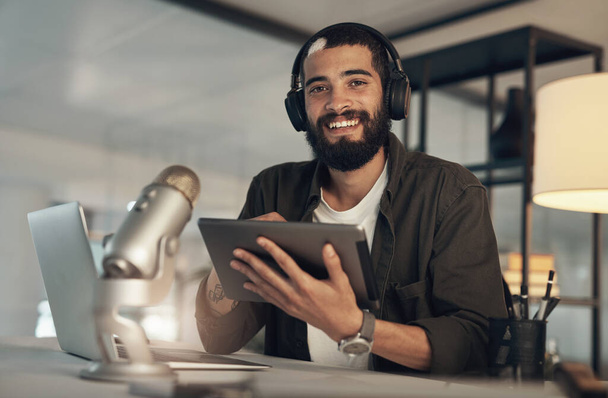 Ein toller Podcast braucht ein tolles Social-Media-Profil. ein junger Mann mit Kopfhörer, Mikrofon und digitalem Tablet während einer späten Arbeitsnacht - Foto, Bild