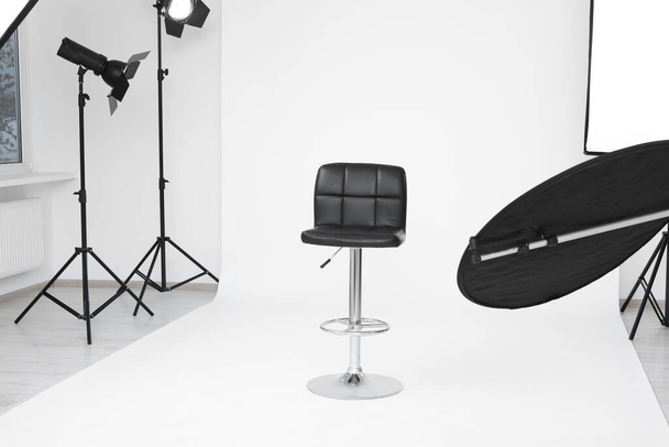 Interior of modern photo studio with bar stool and professional lighting equipment - Fotoğraf, Görsel