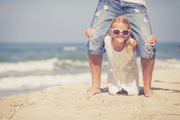 Ojciec i córka gra na plaży w czasie dnia. - Zdjęcie, obraz