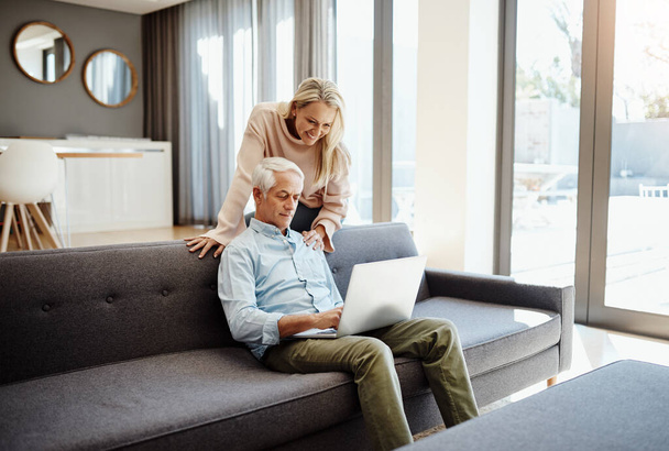 Hows the fibre speed honey. a mature couple using a laptop on the sofa at home - Foto, Bild