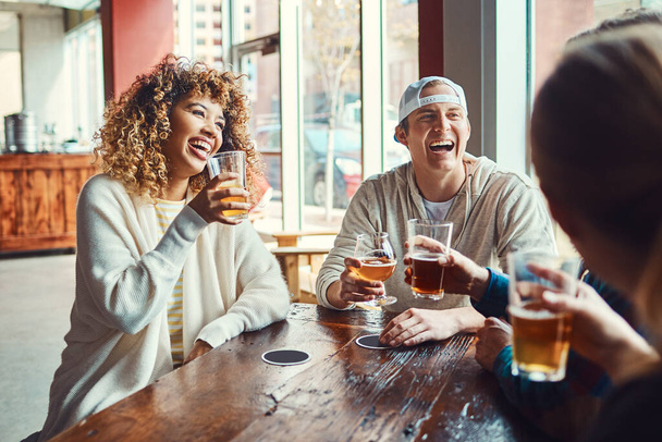 İndirimli içki saati hiç bu kadar mutlu olmamıştı. Bir grup arkadaş barda bira içiyorlar. - Fotoğraf, Görsel