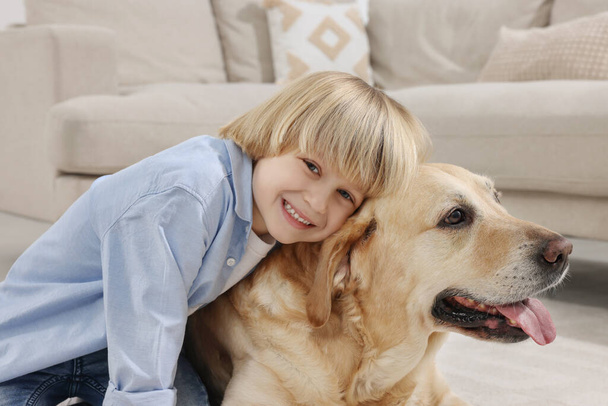 Cute little child with Golden Retriever at home. Adorable pet - Valokuva, kuva