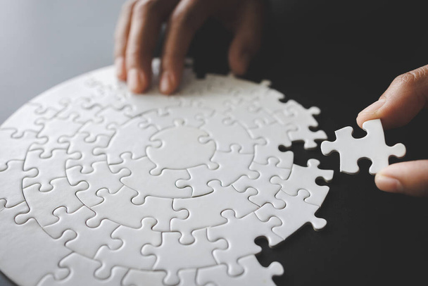 Jigsaw collega un puzzle nelle mani di un uomo d'affari Business team assemblaggio di un puzzle Business e concetto di lavoro di squadra. - Foto, immagini