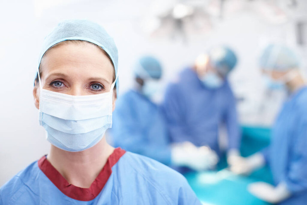 Sağlığın için doğru seçimleri yap. Ameliyathanede maske takan kendine güvenen kadın cerrahın yakın portresi. - Fotoğraf, Görsel