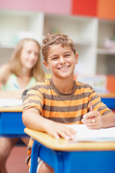 When you love school its easy to achieve. Friendly schoolboy sitting at his desk smiling happily at you - copyspace - Foto, Bild