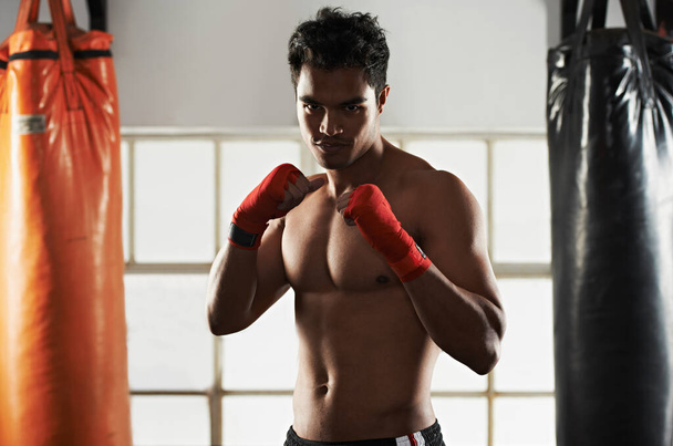 Hes dedicated to the sport of boxing. a young male boxer in a fighting stance - Photo, Image