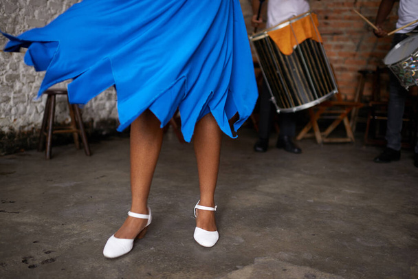 Песня в голубом платье. женщина в синей юбке танцует на сцене с оркестром на заднем плане - Фото, изображение