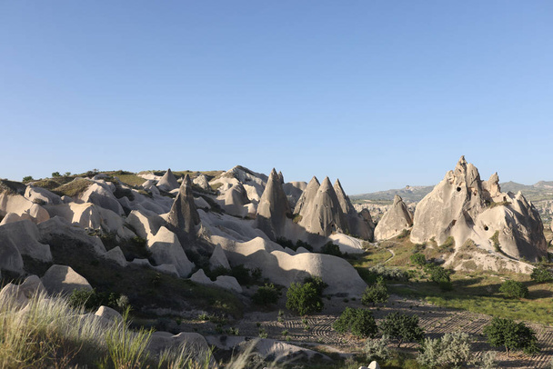 Πορτραίτο των σπηλαίων στο χωριό Uchisar Cappadocia σε φόντο μπλε ουρανού. Πέτρινα αρχαία σπίτια στην Τουρκία. Ταξίδι, περιπέτεια και περιηγήσεις έννοια - Φωτογραφία, εικόνα