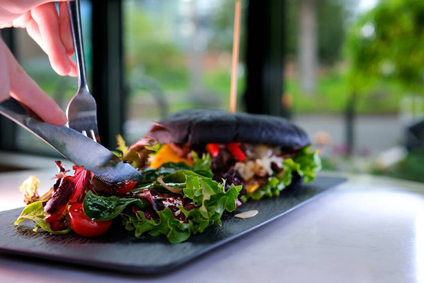 Çatal ve bıçak bir restoranda salata yer. Lezzetli bir öğle yemeği. Öğle yemeği dinlenmesi. - Fotoğraf, Görsel