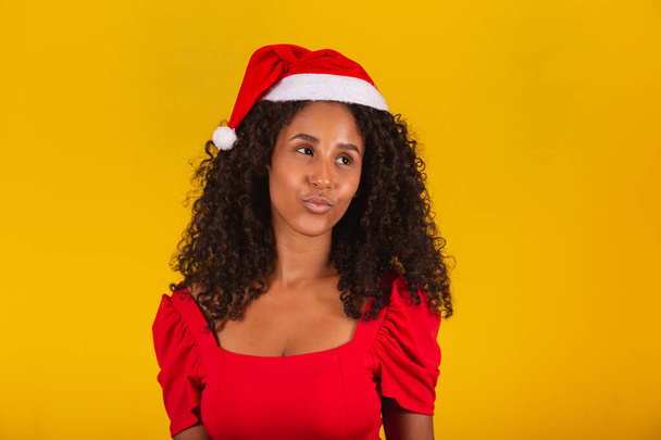 closeup of smiling afro woman with santa hat smiling at camera - Foto, afbeelding