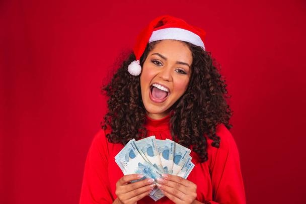 Afro woman counting Brazilian money bills. Real notes. 100 reais bills. Savings concept for the end of the year. Spend the Christmas. Spent on Christmas gifts. - Фото, зображення