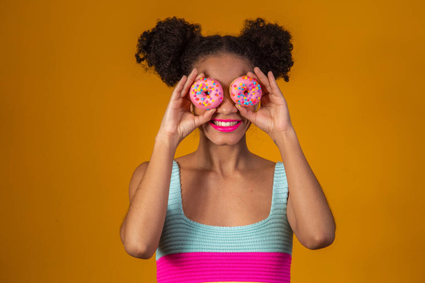 young pretty afro woman with a donut - 写真・画像