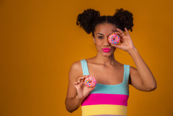 young pretty afro woman with a donut - Fotografie, Obrázek