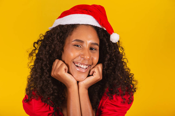 closeup of smiling afro woman with santa hat smiling at camera - Foto, imagen