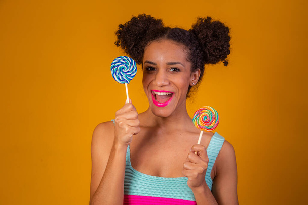 young pretty afro woman with candies - Foto, Imagen