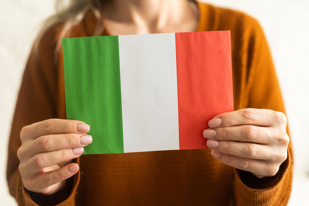 Person holding a Italian flag on a white background. - Fotografie, Obrázek