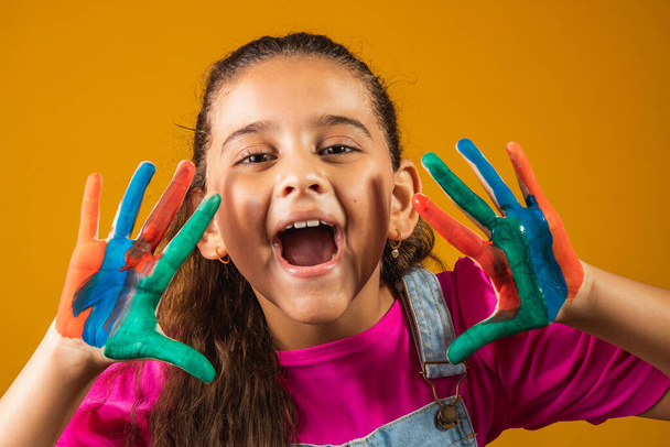 An image of a little girl with her hands in paint - Photo, image