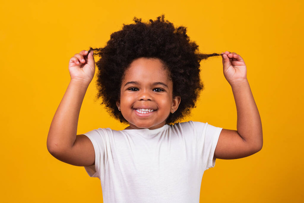 cute afro girl with black power hair smiling at camera. Black Day. Children's Day - Фото, изображение