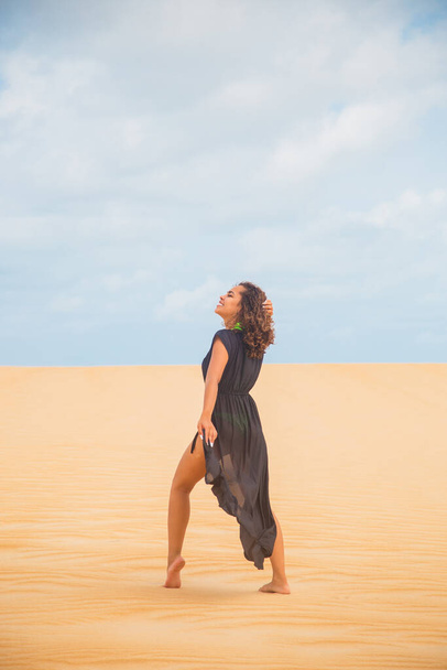 Beautiful young woman posing in the desert sand - Фото, зображення