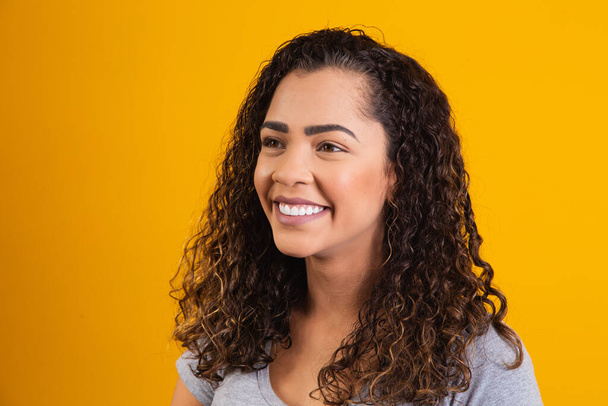 closeup on afro woman face smiling on yellow background with free space for text. Afro woman smiling. - Foto, Imagen