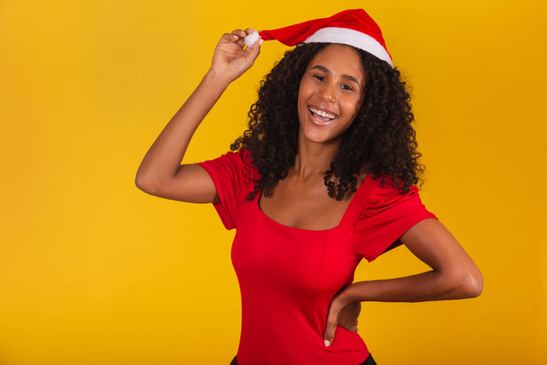 pretty and cheerful girl with Santa hat smiling at camera - Foto, afbeelding