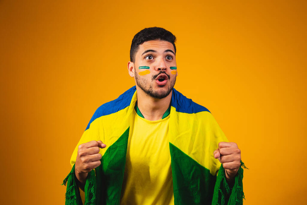 brazilian fan cheering in the crowd on yellow background. - Photo, Image