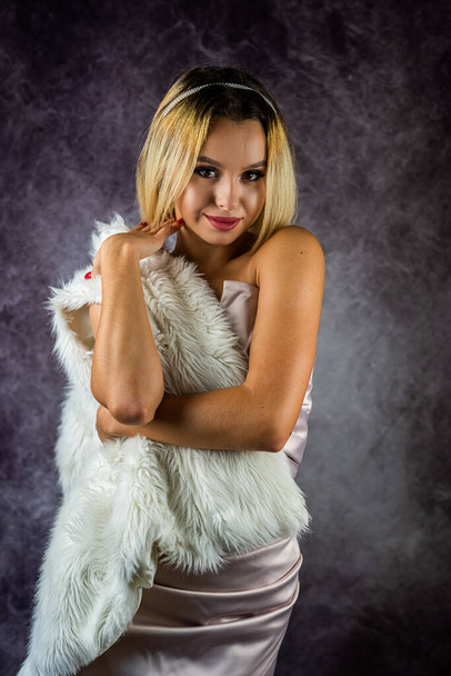 blonde girl in a dress poses in the studio on a plain background. isolated Lady poses in eco coat. Beautiful luxurious woman. Model. portrait - Φωτογραφία, εικόνα