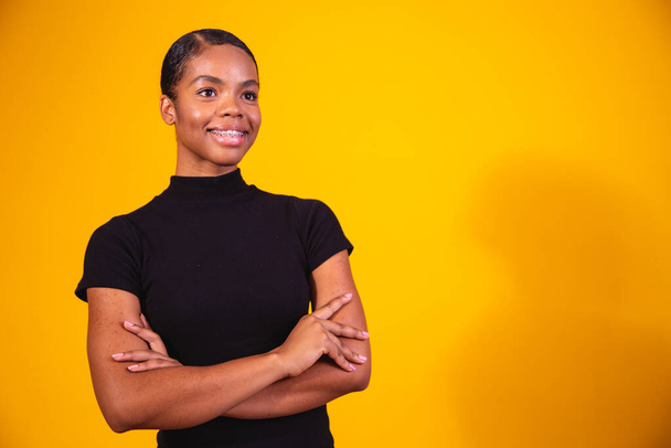 black woman on yellow background with arms crossed. business woman on yellow background - Photo, Image