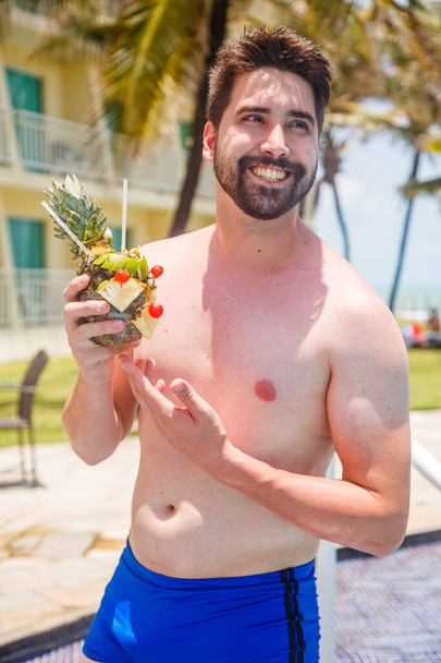 man on vacation in risort drinking sweet pineapple drink. - Фото, зображення
