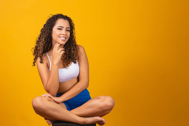 Beautiful young afro woman in fitness outfit smiling looking at camera with space for text.  Horizontal - Фото, зображення