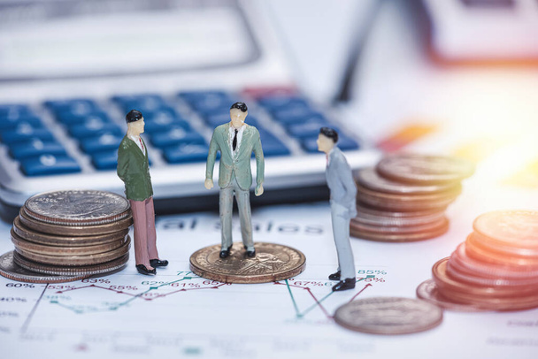  miniaturní lidé setkání stojí na obchodním grafu s mincemi a kalkulačkou, finanční koncept - Fotografie, Obrázek