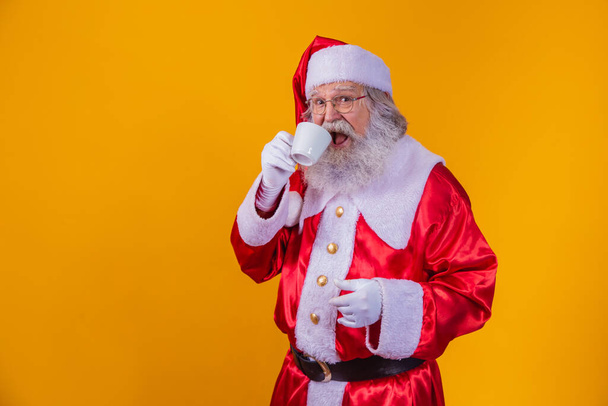 Real Santa having a coffee on yellow background with free space for text. - Фото, изображение