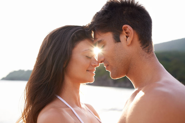 Te és én egymásnak lettünk teremtve. Egy fiatal pár osztozik egy romantikus pillanaton a tengerparton. - Fotó, kép
