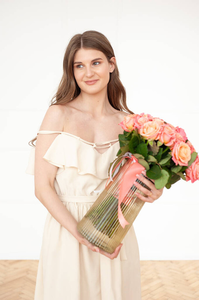 beautiful young woman with bouquet of flowers in hands - Foto, Imagem