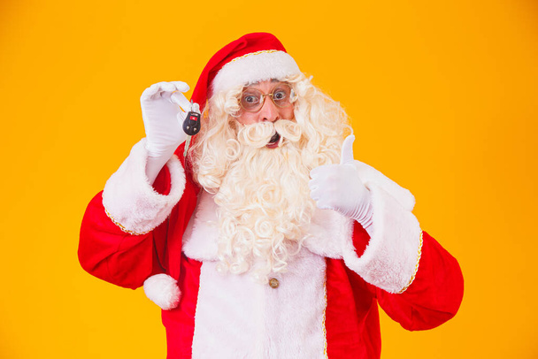 Santa Claus carries car keys in a special year-end promotion - 写真・画像
