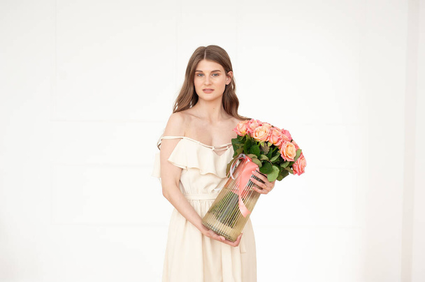 beautiful young woman with bouquet of flowers on white background - Valokuva, kuva