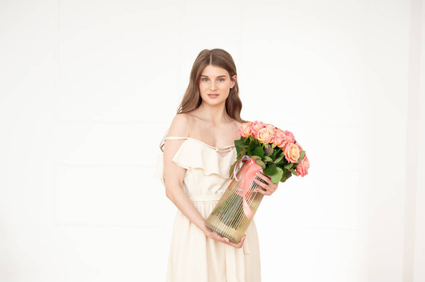 beautiful young woman with bouquet of flowers on white background - Photo, Image