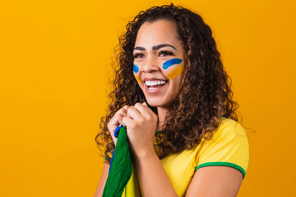 brazilian fan with her face painted in blue and yellow for the b - Фото, изображение