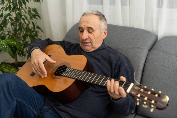 An elderly man is playing guitar. - Foto, Imagem