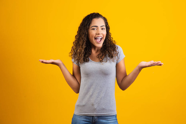 young afro woman smiling on yellow background with free space for text. young student - Фото, изображение