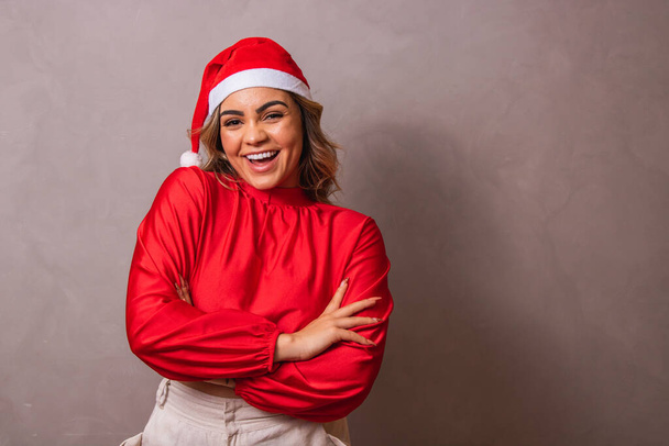Close-up shot of a beautiful young woman with Santa hat and arms crossed. Merry Christmas - Fotoğraf, Görsel