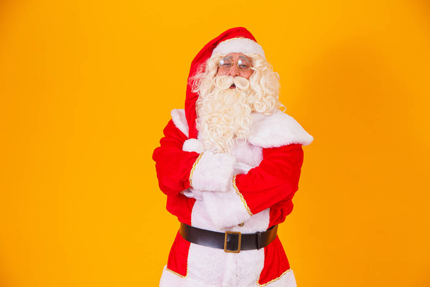 Santa Claus with crossed arms on yellow background. - Фото, зображення